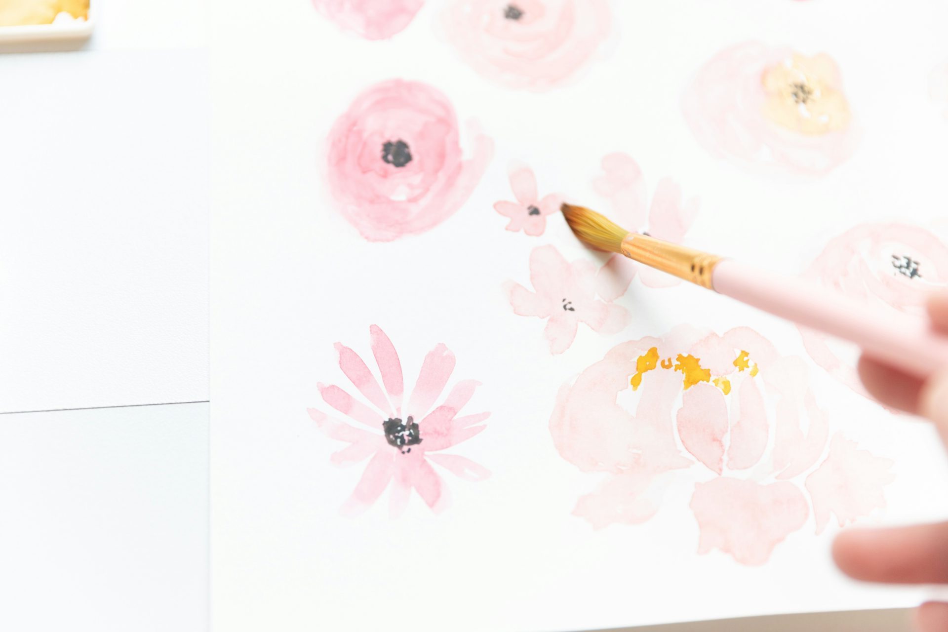 a person holding a pencil and drawing on a piece of paper